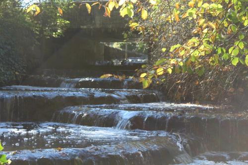 a series of waterfalls with a bridge in the background at Sulkendrup Mølle in Nyborg