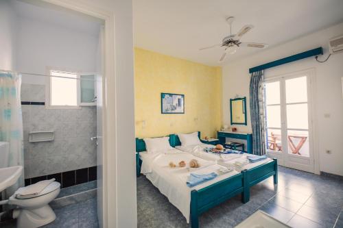 a bedroom with a bed and a bathroom with a toilet at Villa Anna Maria in Aliki