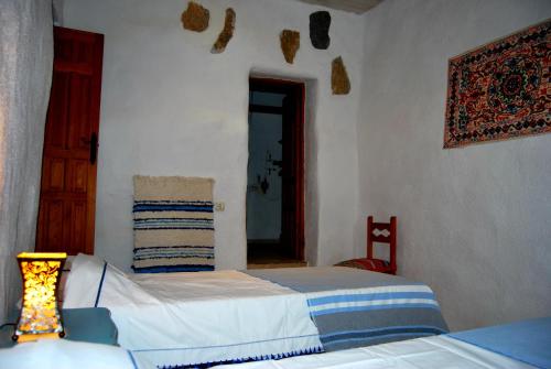 a bedroom with two beds and a lamp in it at Cortijo Los Maximos in Turón