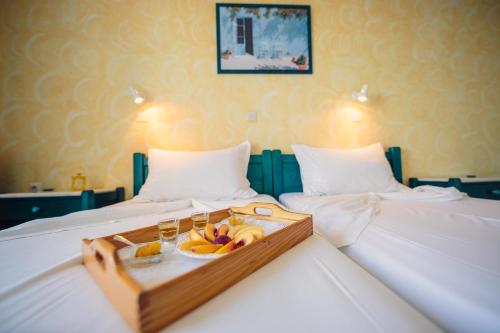 a tray of fruit and drinks on two beds at Villa Anna Maria in Aliki