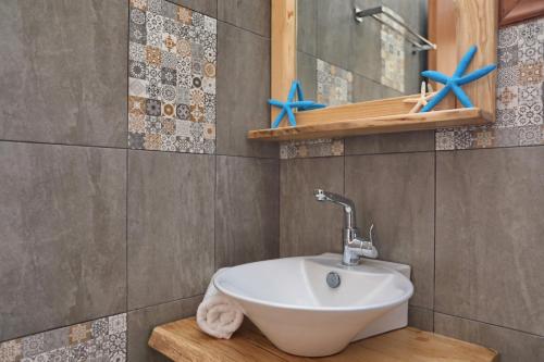 a bathroom with a sink and blue stars on the wall at Giasemi Apartments in Skopelos Town