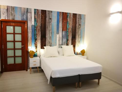 a bedroom with a bed with a large white bedspread at Carulli 69 - Check-in Express apartments in Bari