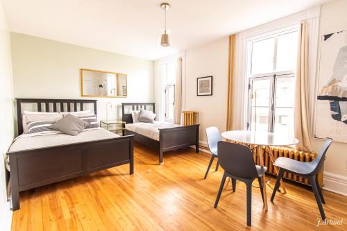 a bedroom with a bed and a table and chairs at Auberge du Plateau in Montréal