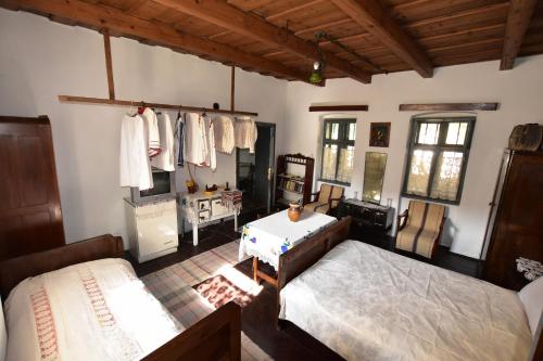 a bedroom with two beds and a desk and windows at Casa Traditionala Ardeleana in Mădăraş