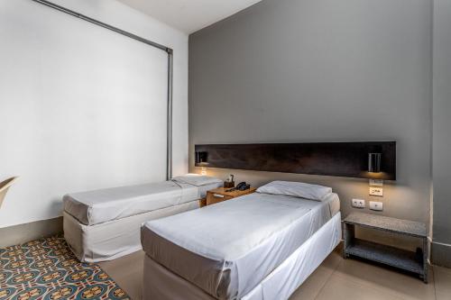 um quarto de hotel com duas camas e uma janela em Hotel Monte Castelo no Rio de Janeiro