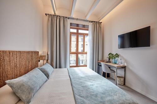 a hotel room with a bed and a television at Ca n'Alexandre - Adults Only in Palma de Mallorca