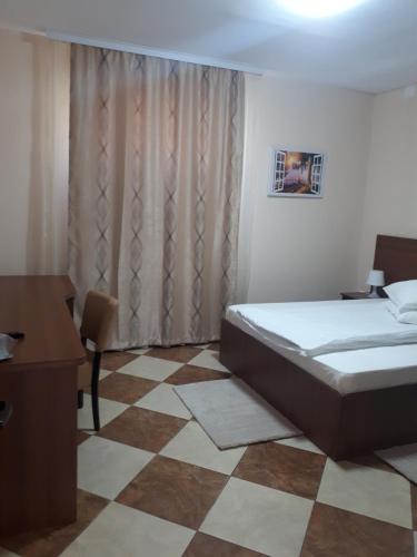 a bedroom with a bed and a desk and a window at Victoria 1 in Campina