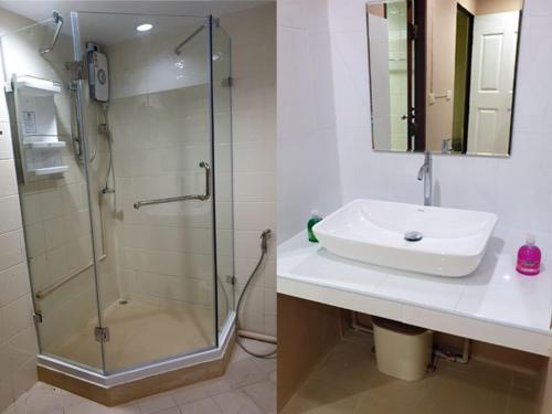 uma casa de banho com uma cabina de duche em vidro e um lavatório. em Oasis Hostel & Bar em Praia de Karon