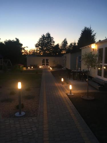 a pathway with lights in a yard at night at Domki u Polki in Sławoszyno