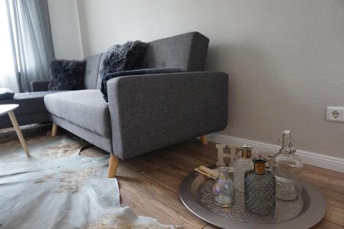 a living room with a couch and a table with bottles at Ferienhaus Hundertmorgenfeld 33 in Wernigerode