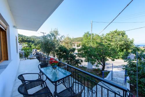 einen Balkon mit einem Tisch mit Blumen darauf in der Unterkunft Johnie's Villa in Neo Klima