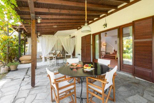 een patio met een tafel en stoelen bij Villa Margaret in Siviri
