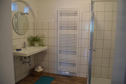 y baño con ducha y lavamanos. en Vintage-Ferienwohnung für 2, en Schörfling am Attersee