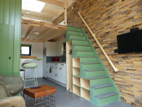 a green staircase in a living room with a kitchen at Trendy Tiny Houses Bovenweg in Rhenen