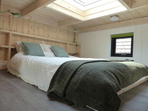 a bedroom with a large bed in a room with a skylight at Trendy Tiny Houses Bovenweg in Rhenen