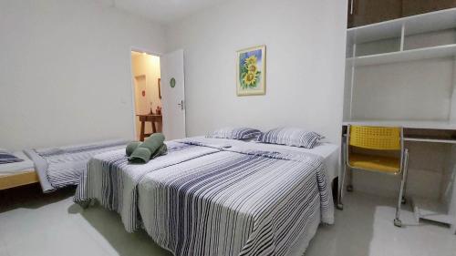 two beds in a room with white walls at A Casa Morro do Moreno in Vila Velha