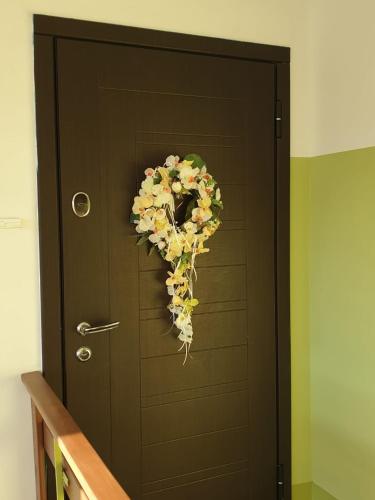 Una puerta con una corona de flores. en Apartamenti Danna, en Lēdmane