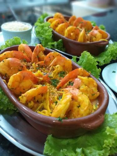 a bowl of shrimp on a plate with lettuce at Hotel Costa Norte Massaguaçu in Caraguatatuba