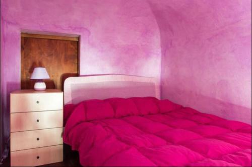 シラクーサにあるRiviera house holidayのピンクのベッドルーム(大型ベッド1台、ドレッサー付)