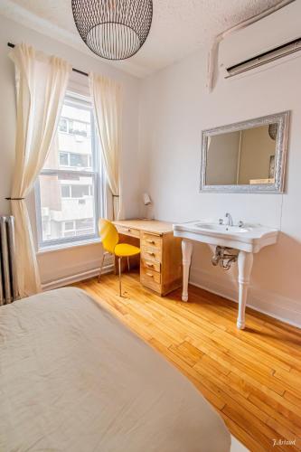 a bathroom with a sink and a mirror at Auberge du Plateau in Montréal