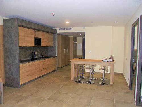 a kitchen with a wooden table and bar stools at Hotel Residence Lido Marana Bastia Furiani in Furiani
