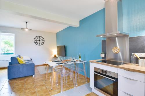 a kitchen with blue walls and a table with chairs at Etape en Bretagne in Port-Louis