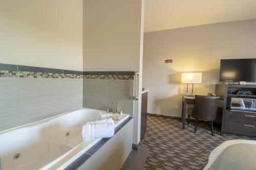 a bathroom with a tub and a sink and a desk at Sunrise Inn in Anacortes
