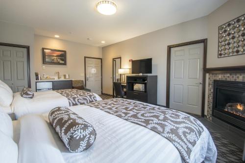 two beds in a room with a fireplace at Sunrise Inn in Anacortes