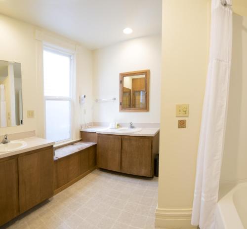 a bathroom with two sinks and a mirror at Sunrise Inn in Anacortes