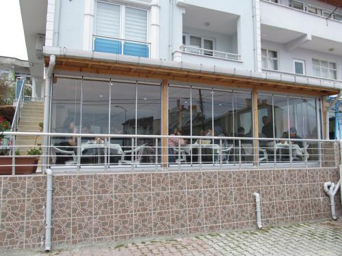 Gerze Apart Otel في غرزي: مجموعة من الناس يجلسون على الطاولات في المبنى