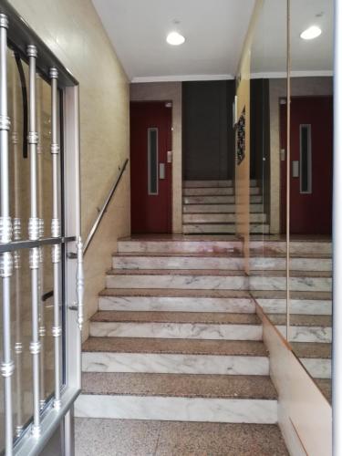 a hallway of a building with stairs and doors at Alojamiento Quintanilla in Gijón