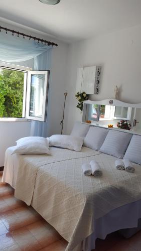 een witte slaapkamer met een groot bed en slippers. bij Apartment BIM in Pisak