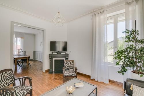a living room with a table and a tv at Maison Qui s'y frotte s'y pique in Robert-Espagne
