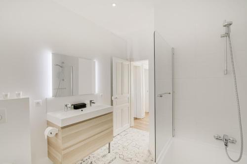 a white bathroom with a sink and a shower at Maison Qui s'y frotte s'y pique in Robert-Espagne