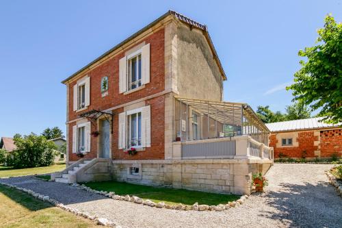 an old brick building with a porch on a yard at Maison Qui s'y frotte s'y pique in Robert-Espagne