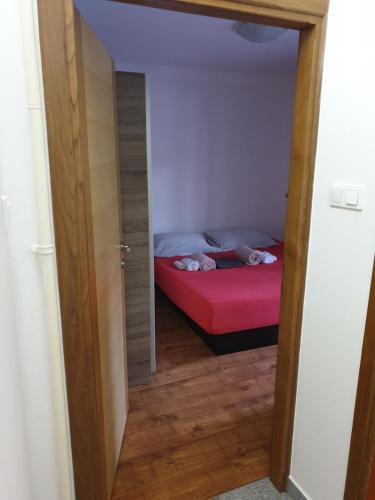 a small bedroom with a bed with a red mattress at Apartman Max 2 in Biškupec Zelinski