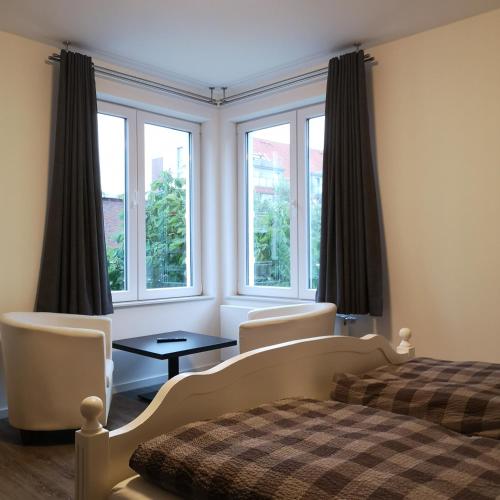 1 dormitorio con 1 cama, 2 sillas y ventanas en Haus Worch en Juist