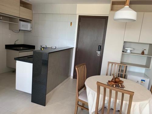 a kitchen with a table and two chairs and a table and a kitchen with at Flat novo no Complexo Heron Marinho in Campina Grande