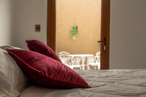 a bed with red pillows on top of it at Hotel Boutique Suri in La Serena