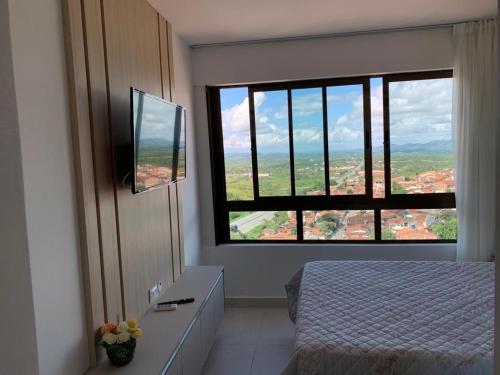 ein Schlafzimmer mit einem Bett und einem großen Fenster in der Unterkunft Flat novo no Complexo Heron Marinho in Campina Grande