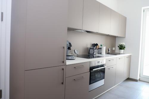 cocina blanca con armarios blancos y horno en high class flat, en Luxemburgo