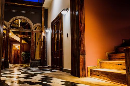a hallway with a checkered floor and wooden doors at Hotel Boutique Suri in La Serena