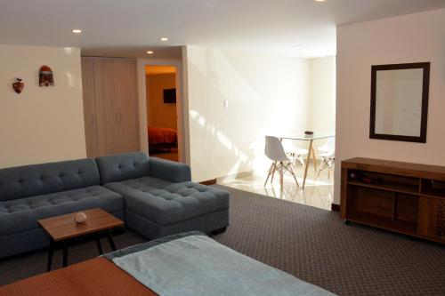a living room with a blue couch and a table at Los Angeles Stay Inn in Quito