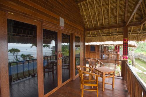 a porch of a house with a table and chairs at Twilight Ceningan in Nusa Lembongan