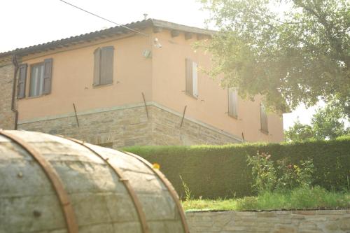 a house in the background with a barrel in front of it at Agriturismo La Caputa in Urbania