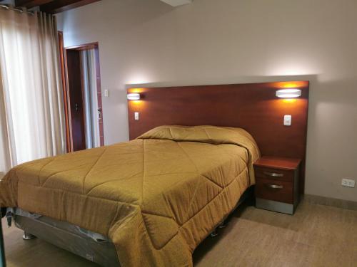 a bedroom with a large bed and a wooden headboard at Residencial Cafferata in Lima