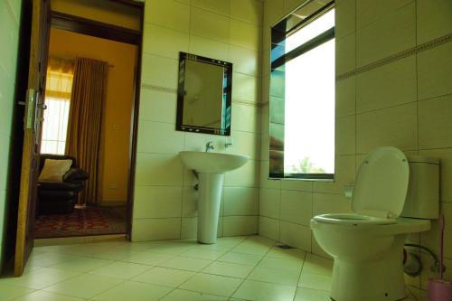 a bathroom with a toilet and a sink at Lakepoint Villa in Entebbe