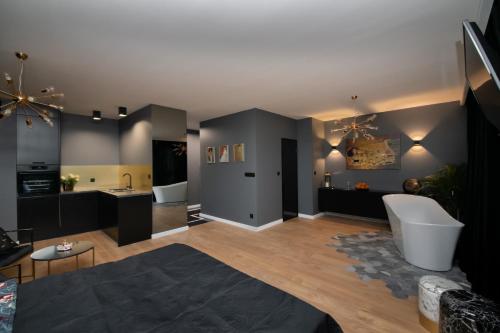 een grote woonkamer met zwarte muren en houten vloeren bij Jacuzzi Suite in Gdańsk