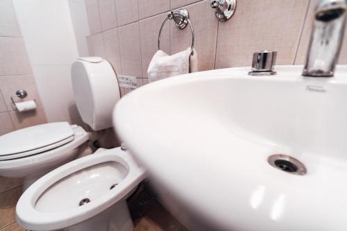 a white bathroom with a toilet and a sink at Hospes - Departamento in San Rafael