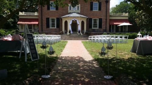 a pathway leading to a building with tables and chairs at Hornsby House Inn in Yorktown